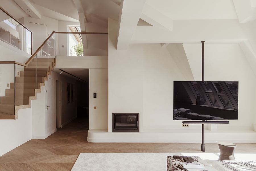 Dachgeschoss-Wohnraum mit offener Treppe und Kamin